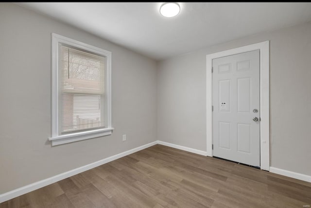 spare room featuring light wood-type flooring and baseboards