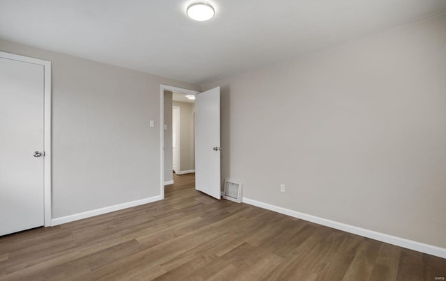 unfurnished bedroom with baseboards, visible vents, and wood finished floors