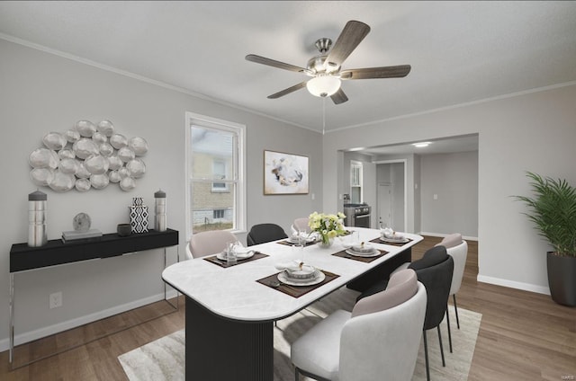 dining space with ceiling fan, ornamental molding, wood finished floors, and baseboards