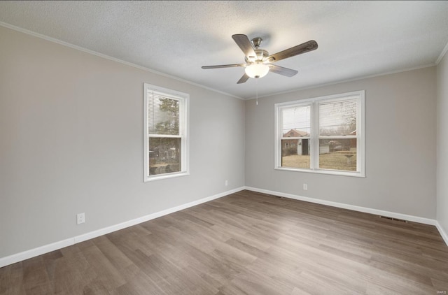 unfurnished room with wood finished floors, a wealth of natural light, and baseboards