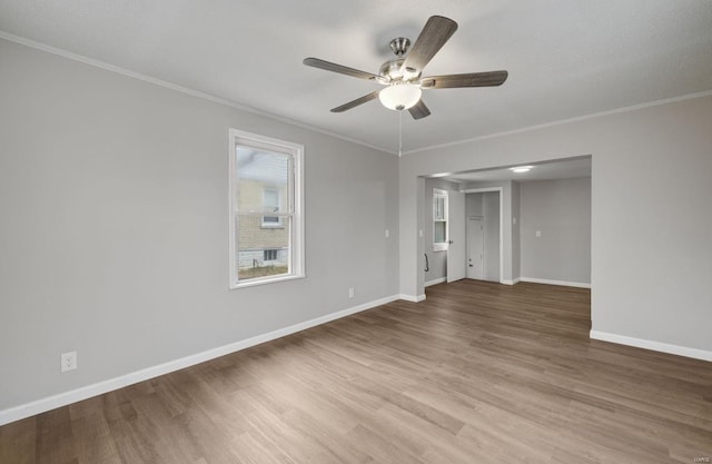 unfurnished room featuring baseboards, ceiling fan, wood finished floors, and crown molding