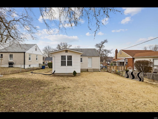 back of property with crawl space, a fenced backyard, a residential view, and a lawn