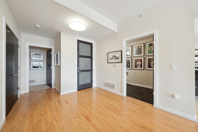 spare room featuring baseboards, visible vents, and hardwood / wood-style floors