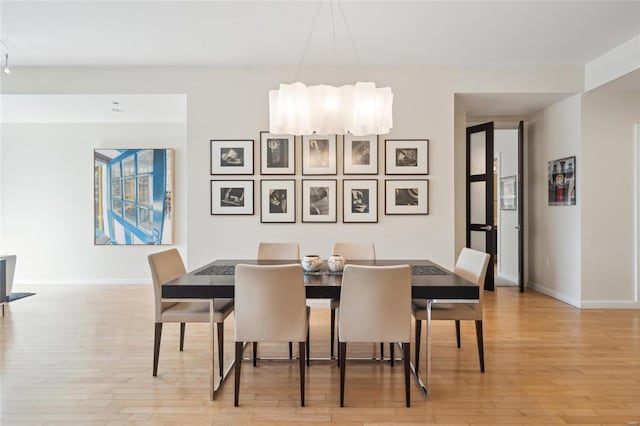 dining space with light wood-style floors and baseboards