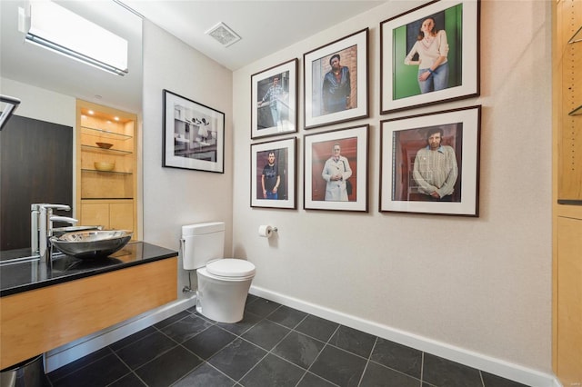 bathroom featuring toilet, visible vents, baseboards, built in features, and tile patterned floors