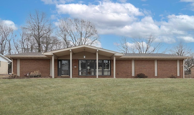 rear view of house with brick siding and a lawn