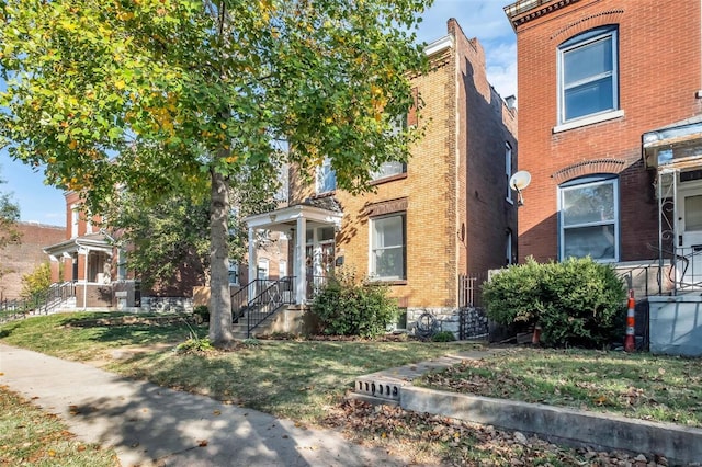 view of front of home with brick siding and a front lawn