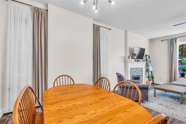 dining space with a fireplace, baseboards, and wood finished floors