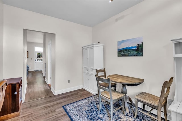 dining area with baseboards and wood finished floors