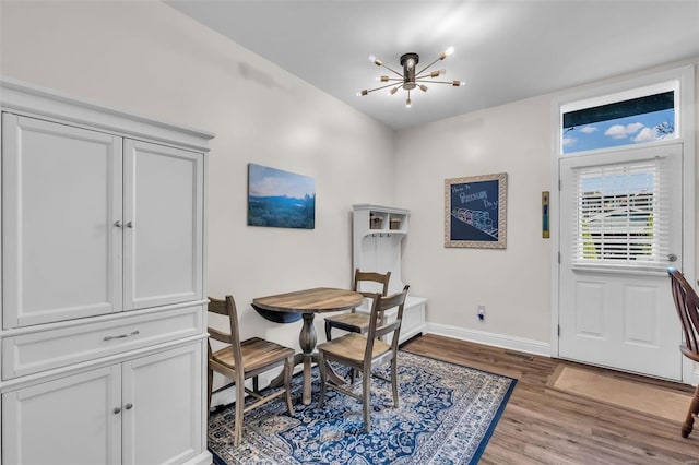 dining space featuring an inviting chandelier, light wood-style flooring, and baseboards