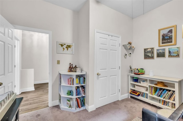 living area featuring carpet and baseboards