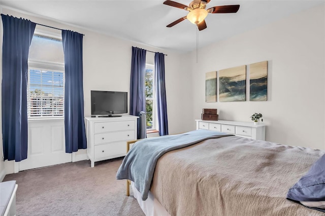 carpeted bedroom with multiple windows and ceiling fan