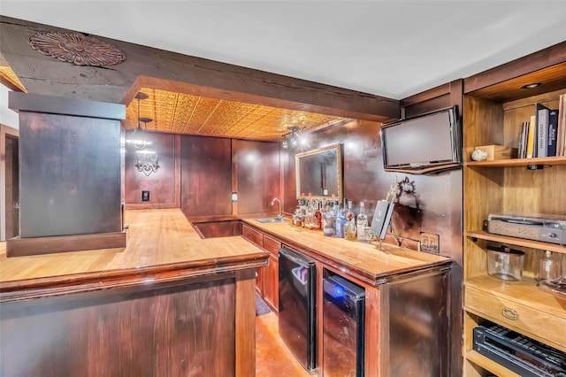 bar featuring beverage cooler, indoor wet bar, light wood-style floors, fridge, and a sink