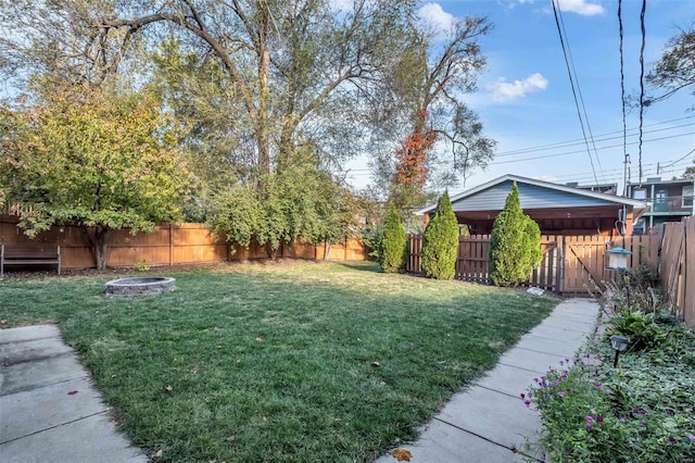 view of yard with a fire pit and a fenced backyard