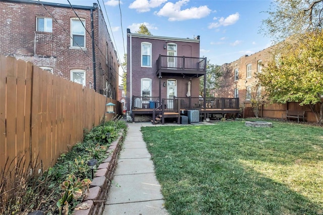 rear view of property featuring a balcony, central AC unit, a yard, a fenced backyard, and a deck