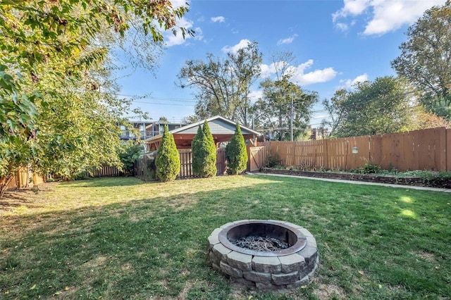 view of yard featuring a fenced backyard and a fire pit