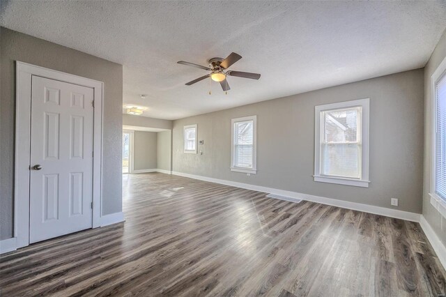 spare room with baseboards, dark wood-type flooring, a ceiling fan, and a textured ceiling