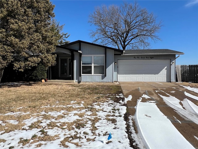 view of front facade with an attached garage, fence, and concrete driveway