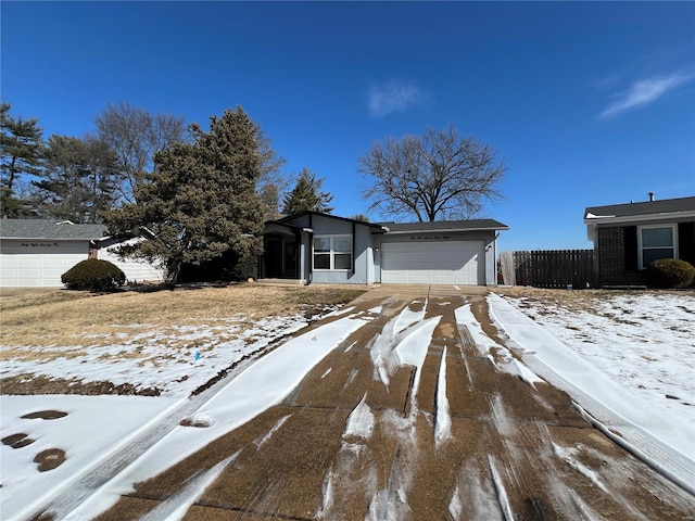 view of front of house featuring an attached garage and fence