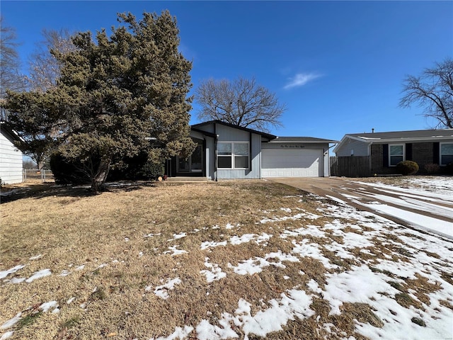 view of front of house featuring an attached garage, fence, and concrete driveway