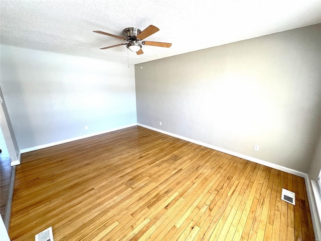 unfurnished room featuring a ceiling fan, a textured ceiling, visible vents, and hardwood / wood-style floors