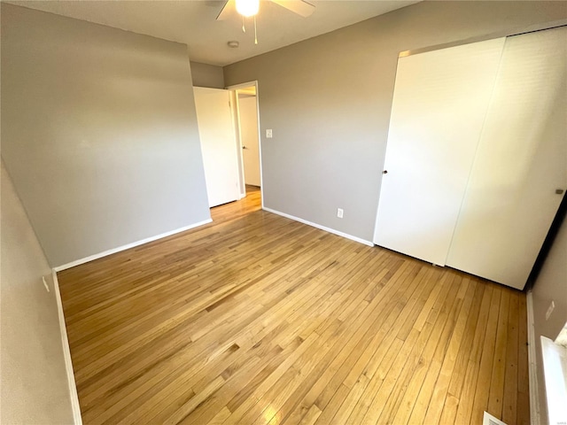 unfurnished bedroom with baseboards, a ceiling fan, and light wood-style floors