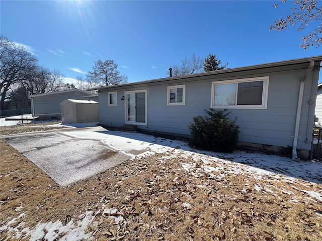 back of house featuring an outbuilding, a patio, and a storage unit