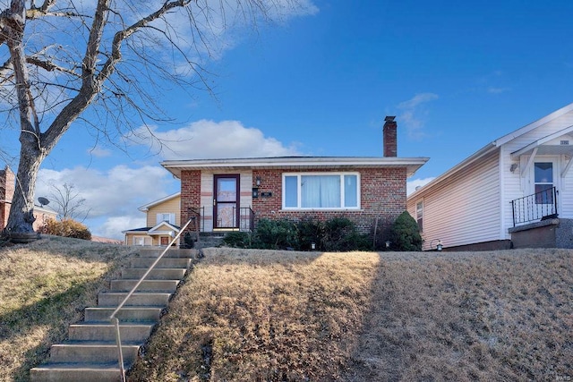 view of front of property featuring brick siding and a chimney