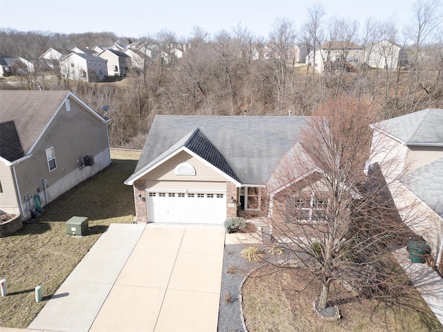 view of front of property with a front yard, an attached garage, a residential view, concrete driveway, and brick siding