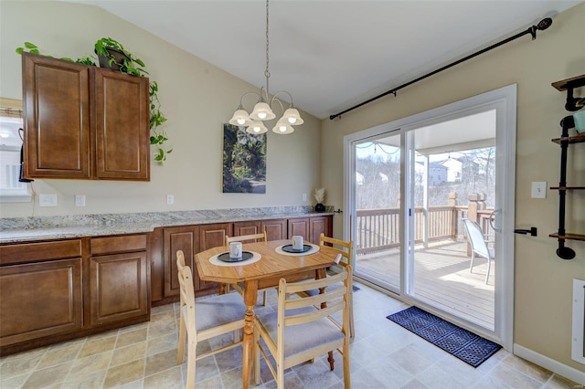 dining area featuring baseboards, an inviting chandelier, and vaulted ceiling