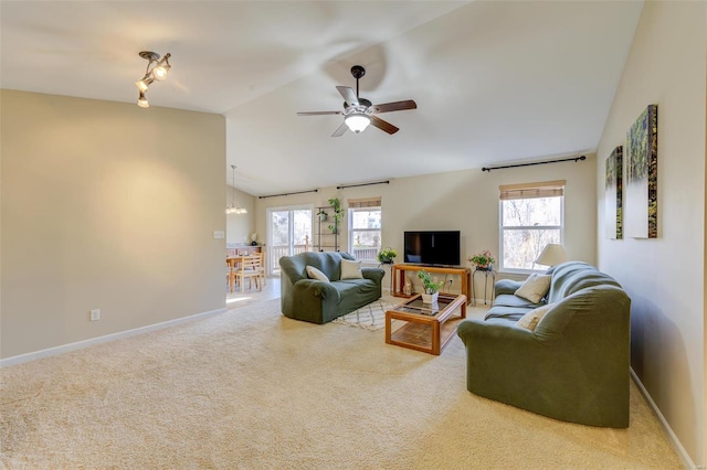 living area featuring vaulted ceiling, a healthy amount of sunlight, baseboards, and carpet floors