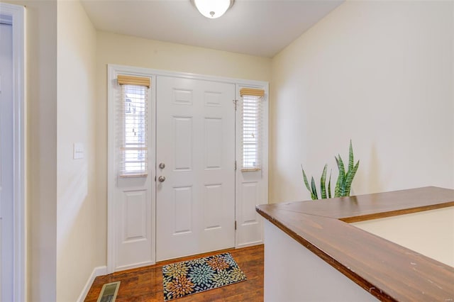 entrance foyer with visible vents, dark wood-style flooring, and baseboards