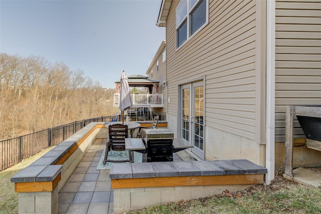 view of patio / terrace featuring french doors, a grill, and fence