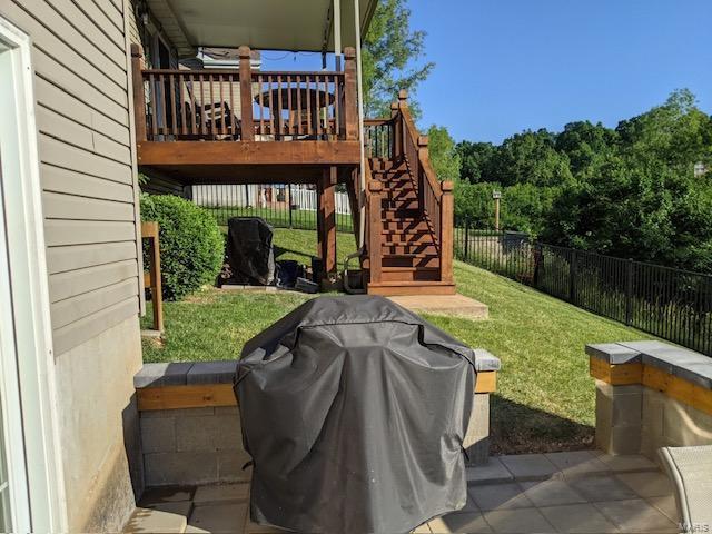 view of yard featuring a wooden deck, stairs, and fence