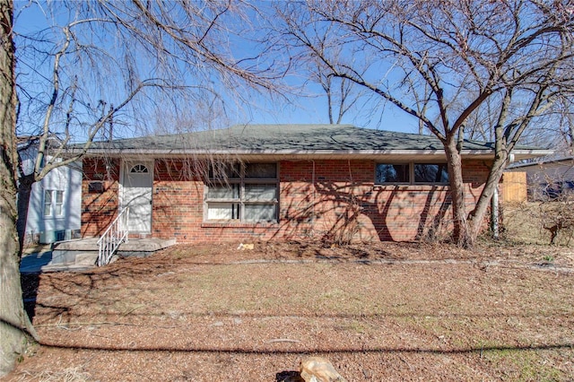 single story home with brick siding and roof with shingles