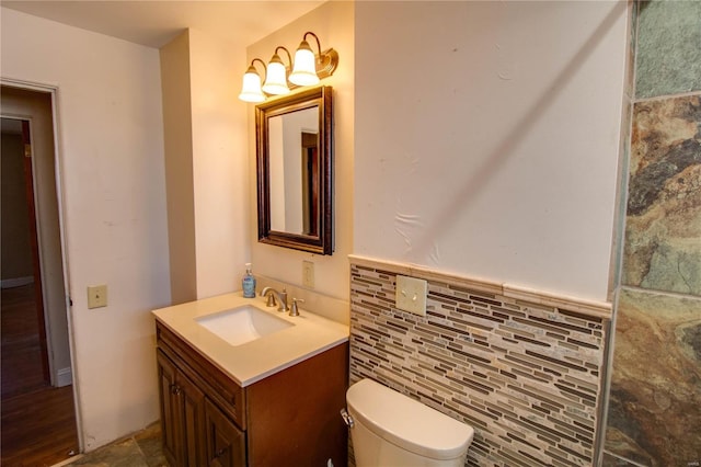 bathroom featuring tile walls, toilet, and vanity