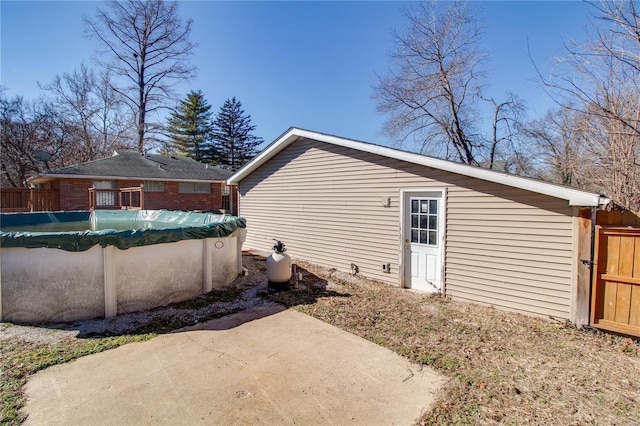 view of side of home featuring a fenced in pool and a patio area