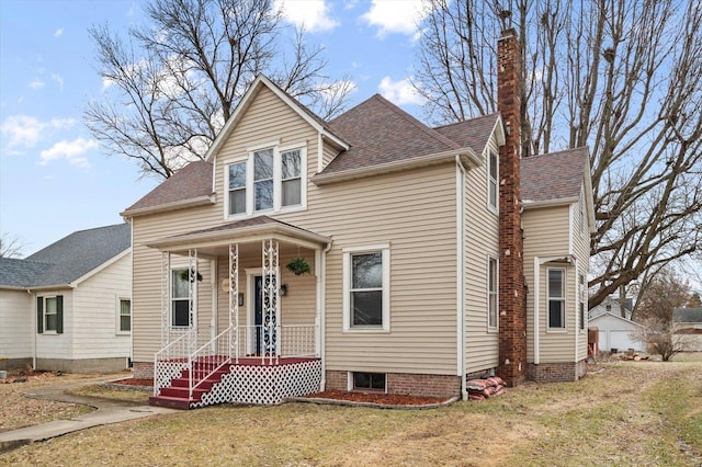 view of front of home with a chimney, a front lawn, and roof with shingles