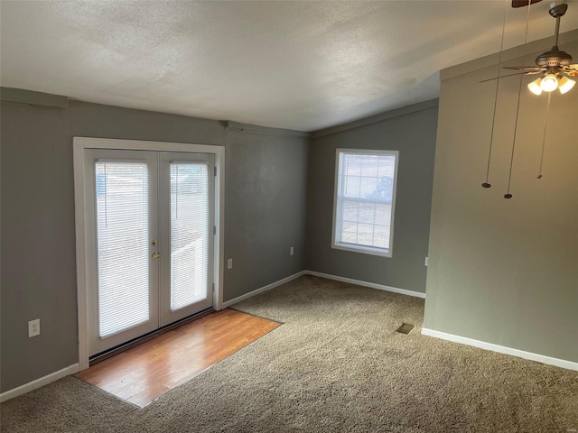 interior space with baseboards, vaulted ceiling, a textured ceiling, french doors, and carpet floors