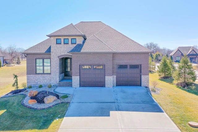 view of front of home featuring driveway, a garage, stone siding, roof with shingles, and a front yard