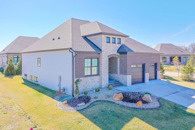 view of front of house with roof with shingles, a front yard, a garage, stone siding, and driveway