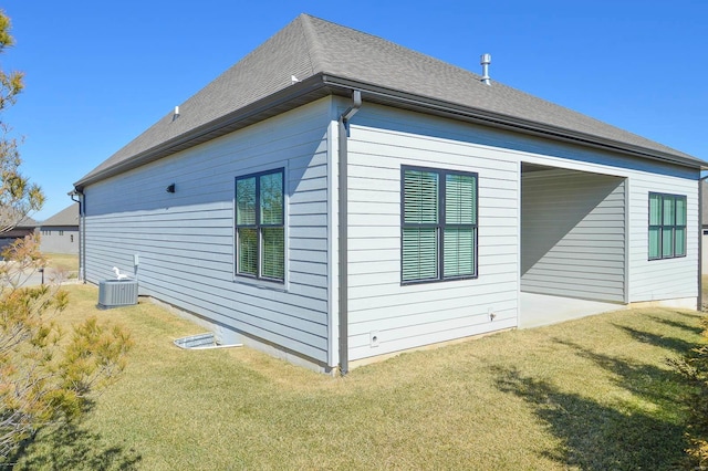 view of property exterior featuring a shingled roof, cooling unit, and a lawn