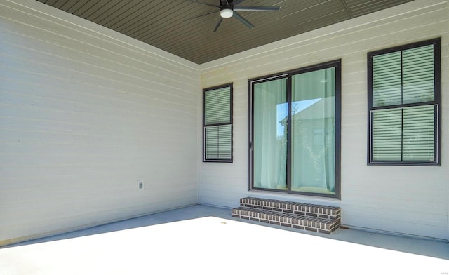 view of exterior entry featuring a patio area and ceiling fan