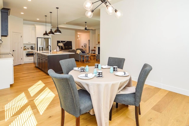 dining area with light wood-style floors, ceiling fan, baseboards, and recessed lighting