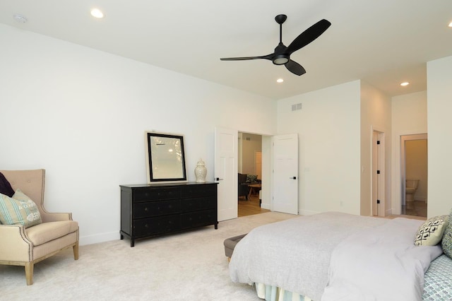 bedroom featuring recessed lighting, light colored carpet, visible vents, baseboards, and ensuite bath