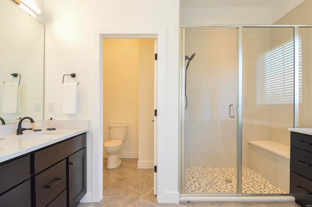 full bathroom with toilet, a shower stall, baseboards, and vanity