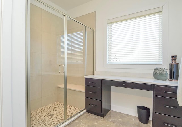 bathroom with marble finish floor and a shower stall