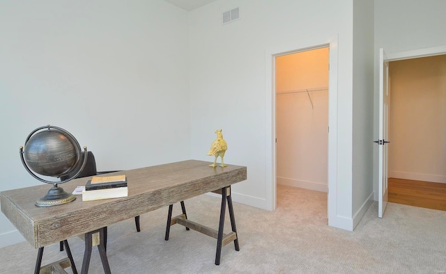 home office featuring light colored carpet, visible vents, and baseboards