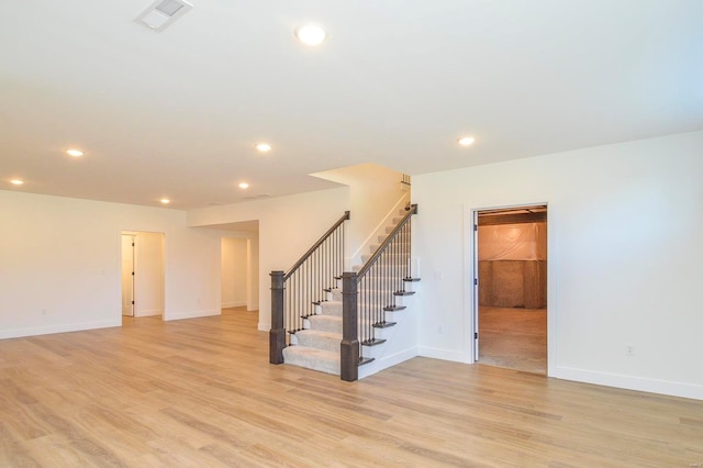 unfurnished room featuring light wood finished floors, stairs, visible vents, and recessed lighting