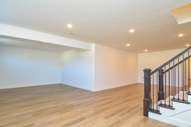 unfurnished room featuring visible vents, baseboards, light wood-style flooring, stairs, and recessed lighting